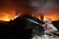 A firefighter tries to control a fire at a garment factory in Savar, outskirts of Dhaka, November 24, 2012. REUTERS/Andrew Biraj