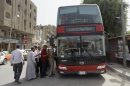 People board a double-decker bus in downtown Baghdad, Iraq, Wednesday, May 30, 2012. Iraqis are hailing the return of red double-decker buses to Baghdad's streets, a sign that the country is trying to restore some normalcy after a decade of war, sanctions and sectarian violence. (AP Photo/Khalid Mohammed)