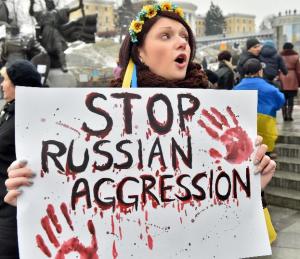 A girl wearing Ukrainian flag shouts slogan as she …