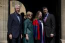 Former U.S. Secretary of State Hillary Rodham Clinton, second left, before taking her sunglasses off poses for a group photograph with her husband former U.S. President Bill Clinton, left, their daughter Chelsea, third left, and her husband Marc Mezvinsky, after they all attended Chelsea's Oxford University graduation ceremony at the Sheldonian Theatre in Oxford, England, Saturday, May 10, 2014. Chelsea Clinton received her doctorate degree in international relations on Saturday from the prestigious British university. Her father was a Rhodes scholar at Oxford from 1968 to 1970. The graduation ceremony comes as her mother is considering a potential 2016 presidential campaign. (AP Photo/Matt Dunham)
