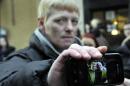Glasgow resident John McGarrigle, 38, displays mobile phone showing a picture of himself with his father, who he believes was killed, at a police cordon in Glasgow on November 30, 2013