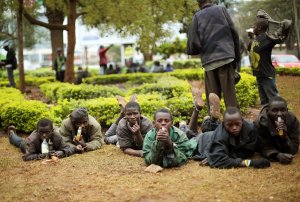 Street children watch media and others gather at a …