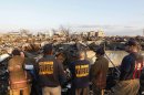 Members of the New Orleans Fire Department tour a neighborhood of burnt houses damaged during Hurricane Sandy, in the Breezy Point area of New York's borough of Queens
