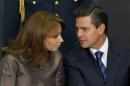 FILE - In this March 13, 2013 file photo, Mexico's President Enrique Pena Nieto, right, speaks to his wife Angelica Rivera as they attend a ceremony launching the program "Life insurance for female heads of family" at Los Pinos presidential residence in Mexico City. Pena Nieto is facing a rising tide of angry protests over the disappearance of 43 students and increasingly sharp questions about his wife's purchase of a Mexico City mansion from a company that had won juicy contracts from him. (AP Photo/Eduardo Verdugo, File)