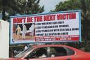 A car drives past a public health advertisement against the Ebola virus in Monrovia