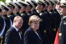 Russian President Vladimir Putin (L) and German Chancellor Angela Merkel attend a wreath-laying ceremony at the Tomb of the Unknown Soldier by the Kremlin Wall in Moscow on May 10, 2015