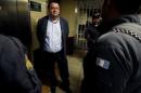 Police officers escort Costa Rican Alejandro Jimenez Gonzalez, also known as "El Palidejo" one of five men charged in the 2011 murder of popular Argentine folk singer Facundo Cabral as he arrives to listen to the verdict at a court room in Guatemala City