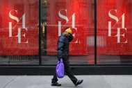 A man walks past a shop while carrying a shopping bag in New York, December 26, 2012. REUTERS/Eduardo Munoz