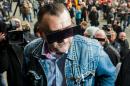 Lutz Bachmann, founder of Germany's anti-Islamic Pegida movement arrives for his trial on April 19, 2016 in Dresden, his eyes covered