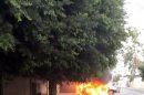 Burning car is seen in front of the Russian embassy, as it came under attack in Tripoli