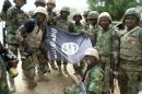 A picture from the Nigerian military taken on February 26, 2015 shows troops posing with a flag of Boko Haram after dismantling one of their camps along Djimitillo Damaturu road, Yobe State in northeastern Nigeria