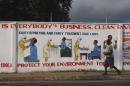 A man walks by a mural with health instructions on treating the Ebola virus, in Monrovia