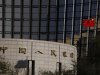 China's nation flag flies in front of the headquarters of the People's Bank of China, the central bank, in Beijing