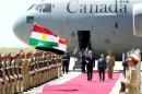 Canada's Prime Minister Harper and Iraq's Kurdish regional President Barzani walk during a welcoming ceremony after arriving at the airport in Erbil