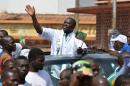 Central African Republic presidential candidate Agustin Agou waves at supporters during a campaign rally in Bangui on December 25, 2015 ahead of the country's presidential election