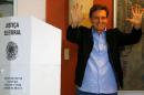 Senator Marcelo Crivella, candidate for Rio de Janeiro mayor, gestures to photographers after voting during the municipal elections at a polling station in Rio de Janeiro
