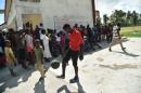 People gather outside the Lycee Jean Claudy Museau school where refugees of Hurricane Matthew are currently housed in Les Cayes, in the south west of Haiti, on November 16, 2016
