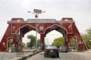 Vehicles drive through the city gate located along Jos Road, after the military declared a 24-hour curfew over large parts of Maiduguri in Borno State