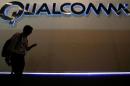 A man walks past Qualcomm stand while attending during the Mobile World Congress in Barcelona