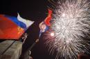 People watch fireworks at the central Nakhimov square in Sevastopol, Crimea, on Friday, March 21, 2014. Russian President Vladimir Putin completed the annexation of Crimea on Friday, signing a law making the Black Sea peninsula part of Russia. (AP Photo/Andrew Lubimov)