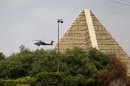 A military attack helicopter flies over the memorial of the unknown soldiers during the funeral for Giza Police Gen. Nabil Farrag in Cairo, Egypt, Friday, Sept. 20, 2013. Farrag was killed after unidentified militants opened fire on security forces deployed Thursday to the town of Kerdasa to drive off suspected Islamists taking control of the town near Giza Pyramids. (AP Photo/Hassan Ammar)