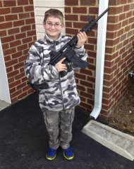 CORRECTS BOY'S AGE TO 10 - This undated photo provided by Shawn Moore shows his son Josh, 10, holding a rifle his father gave him for his 11th birthday, at their home in Carneys Point, N.J. The Moore family claims this photo, posted on Facebook, led the state’s child welfare agency to the family’s house, Friday, March 15, 2013, demanding to be let inside to inspect their guns. (AP Photo/Shawn Moore)