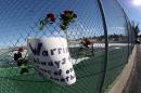 Roses and a sign of support are woven into a cyclone fence around a tennis court at Arapahoe High School in Centennial, Colo., on Saturday, Dec. 14, 2013. The school was the scene of a shooting on Friday that left a student gunman dead and two other students injured. (AP Photo/David Zalubowski)