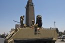 Egyptian soldiers stand guard on top of their armoured personnel carrier near Cairo's Tahrir square on July 26, 2013