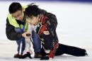 Yuzuru Hanyu, right, of Japan is helped by a medical team member after he clashed with Yan Han of China during a practice prior to their free program performance at the Cup of China in Shanghai, China Saturday, Nov. 8, 2014. (AP Photo/Kyodo News) JAPAN OUT, MANDATORY CREDIT