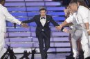 Host Ryan Seacrest arrives on the stage during the 11th season finale of "American Idol" in Los Angeles