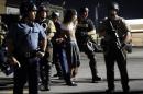 A man is arrested as police try to disperse a crowd in Ferguson, Mo. early Wednesday, Aug. 20, 2014. On Saturday, Aug. 9, 2014, a white police officer fatally shot Michael Brown, an unarmed black teenager, in the St. Louis suburb. (AP Photo/Jeff Roberson)