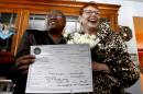 Holding their Illinois marriage license, Vernita Gray, left, and Patricia Ewert smile at friends after they were married by Cook County Judge Patricia Logue, the first gay marriage in Illinois, at the couple's home Wednesday, Nov. 27, 2013, in Chicago. U.S. District Judge Thomas Durkin on Monday, Nov. 25, 2013, ordered the Cook County clerk to issue an expedited marriage license to Gray and Ewert before the state's gay marriage law takes effect in June 2014, because Gray is terminally ill. (AP Photo/Charles Rex Arbogast)