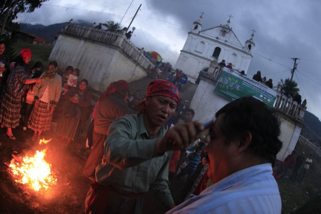 Man is "cleansed" next to a sacred fire during pre-Hispanic mass of "Segunda Conexion" outside Chi Ixim church in Tactic
