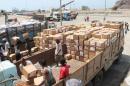 Yemeni workers unload medical aid boxes from a boat carrying 460 tonnes of Emirati relief aid that docked in the port of the city of Aden into a truck, on May 24, 2015