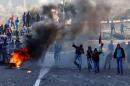 Israeli Arab youths throw stones during clashes with Israeli police at the entrance to the town of Kfar Kanna
