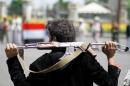 An armed man loyal to the Houthi movement holds his weapon as he gathers to protest against the Saudi-backed exiled government deciding to cut off the Yemeni central bank from the outside world, in the capital Sanaa