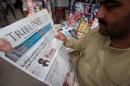 A man reads a newspaper containing news about Afghan Taliban leader Mullah Akhtar Mansour at a stall in Peshawar