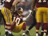 Washington Redskins' Griffin is helped up after being tackled by Baltimore Ravens defense during their NFL football game in Landover