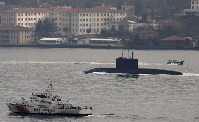 Russia's diesel-electric submarine Rostov-on-Don is escorted by a Turkish Navy Coast Guard boat as it sets sail in the Bosphorus, on its way to the Bl...