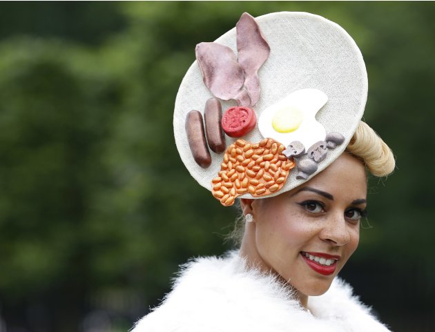 A race goer poses wearing a hat featuring a full English breakfast at Royal Ascot on Ladies&#39; Day, southwest of London