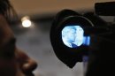 Canadian Prime Minister Stephen Harper is seen through a television camera scope speaking at the Council on Foreign Relations in New York