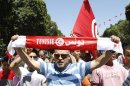 A supporter of the Islamist Ennahda movement holds up a scarf as he chants slogans during a demonstration in Tunis