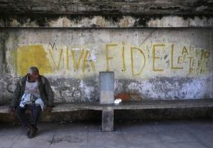 A man sits near graffiti reading &quot;long live Fidel&quot; &hellip;