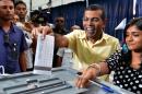 Maldivian former president and presidential candidate Mohamed Nasheed (2nd R) casts his vote at a local polling station in Male on November 9, 2013
