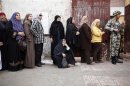 A elderly woman sits as she queues outside a polling center to vote during a referendum on Egypt's new constitution in Cairo