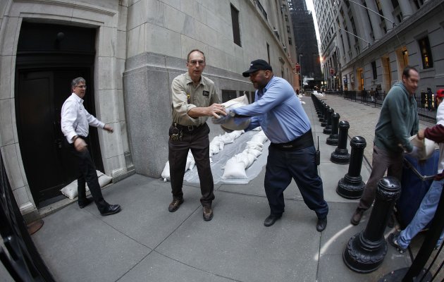 New York Stock Exchange workers place sand bags in front of doors and over electrical vaults at the exchange in New York