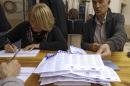 Workers count the ballots in the regional elections, Sunday, Dec. 13, 2015, in Nice, southeastern France. Far-right National Front party collapsed in French regional elections Sunday after dominating the first round of voting, according to pollsters' projections.(AP Photo/Lionel Cironneau)