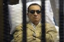FILE - In this June 2, 2012 file photo, Egypt's ex-President Hosni Mubarak lays on a gurney inside a barred cage in the police academy courthouse in Cairo, Egypt. An Egyptian security official says ousted president Hosni Mubarak has been interrogated over gifts worth millions of Egyptian pounds (hundreds of thousands of US dollars) he allegedly received from the country's top newspaper as a show of loyalty while he was in power. Mubarak is serving a life sentence after being convicted for failing to stop killings of protesters during 2011 uprising. (AP Photo/File)