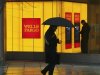 File photo of a man walking past a Wells Fargo Bank branch on a rainy morning in Washington