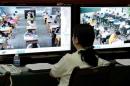A staff from the city's command centre of education exams watches real time monitors showing students taking the National College Entrance Exams in Chongqing
